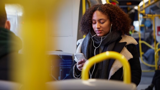 ung kvinne ser på mobiltelefon i tog
