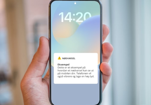 Hånd som holder en mobiltelefon med illustrasjon av varsel
